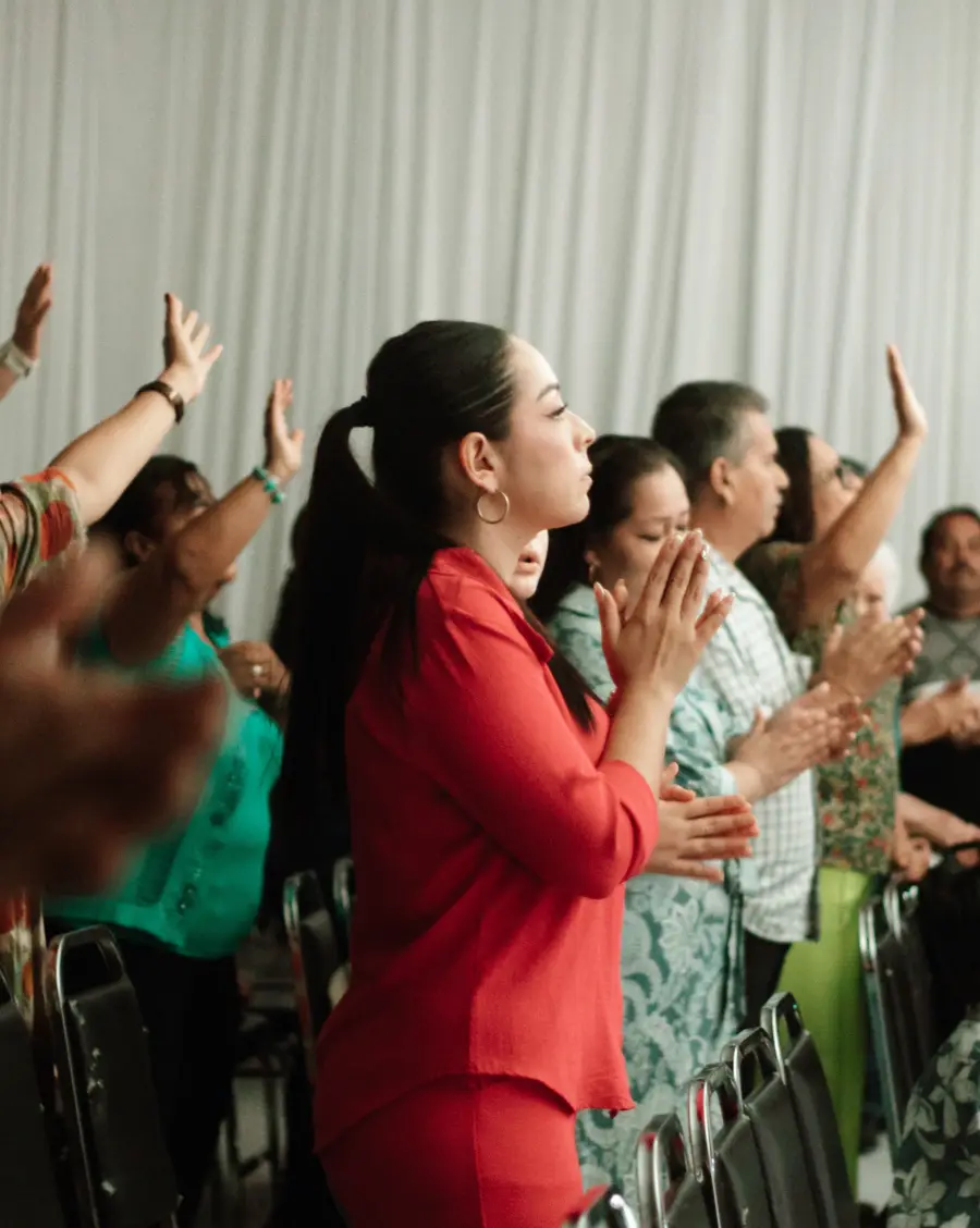 Mujeres alabando con las manos alzadas